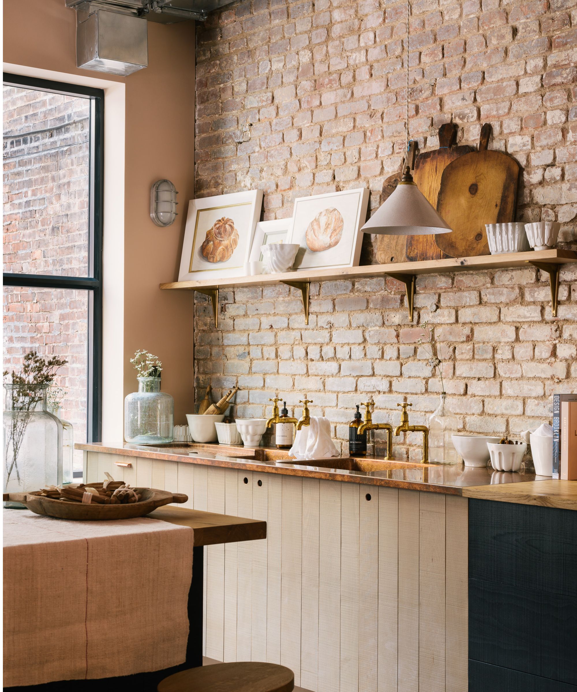 kitchen with brick wall, wooden cabinets and wooden gallery shelf with decor