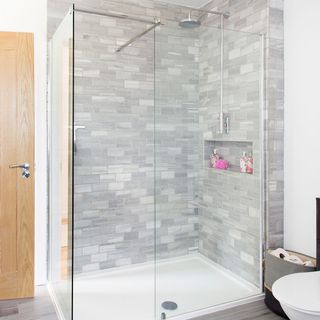 bathroom with shower glass cabin grey brick wall and shower