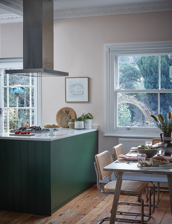 A kitchen with a dark green island