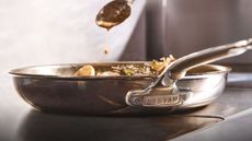 A shot of the logo on the Hestan ProBond Luxe Professional Clad Stainless-Steel Skillet, while basting a steak