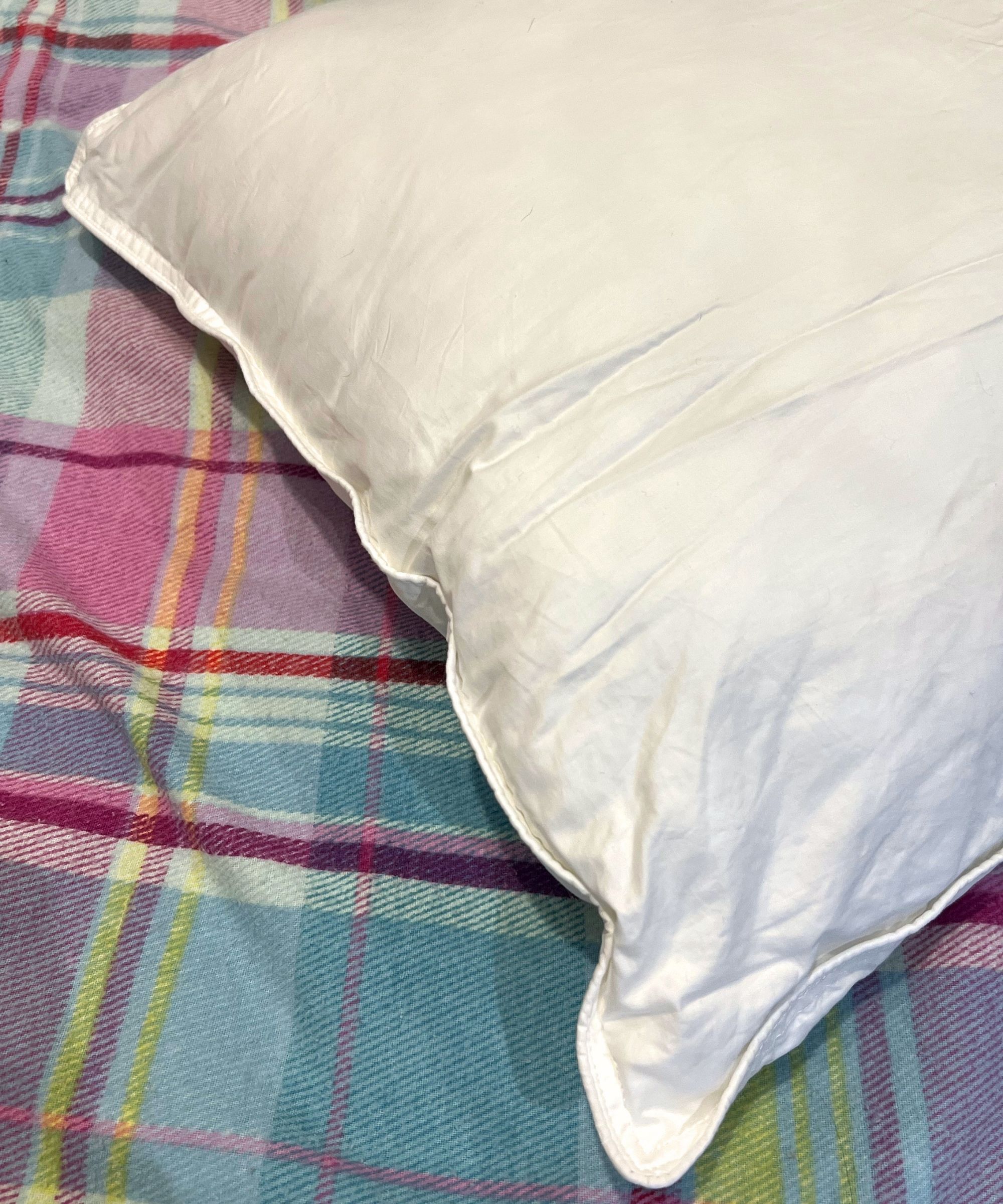 Brooklinen down alternative pillow on colorful plaid bedding