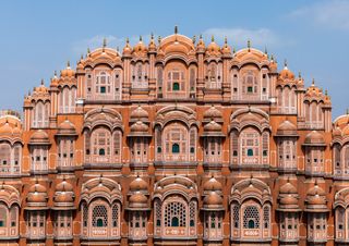 The pink and red sandstone exterior of the Hawa Mahal in Jaipur, India