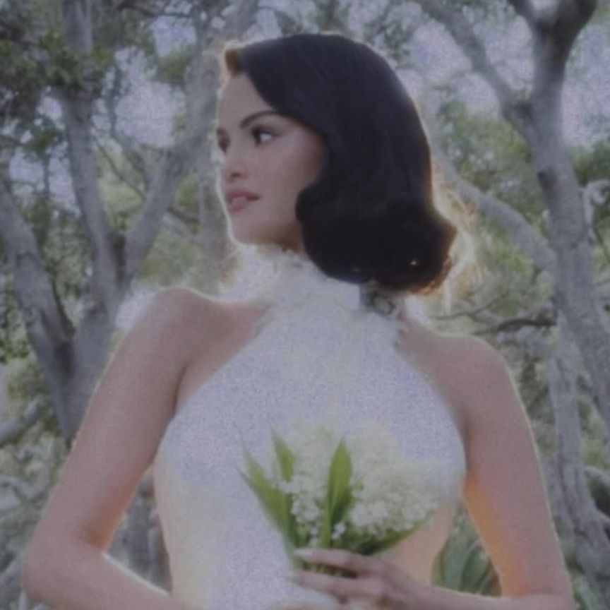 selena gomez wearing a white wedding dress holding a bouquet of white flowers
