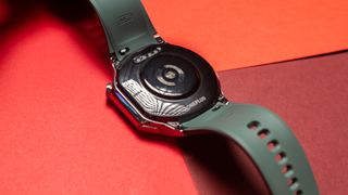 Back of OnePlus Watch 2 against red background
