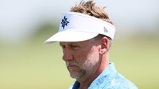 Ian Poulter wearing a sky blue polo and white visor during a LIV Golf tournament