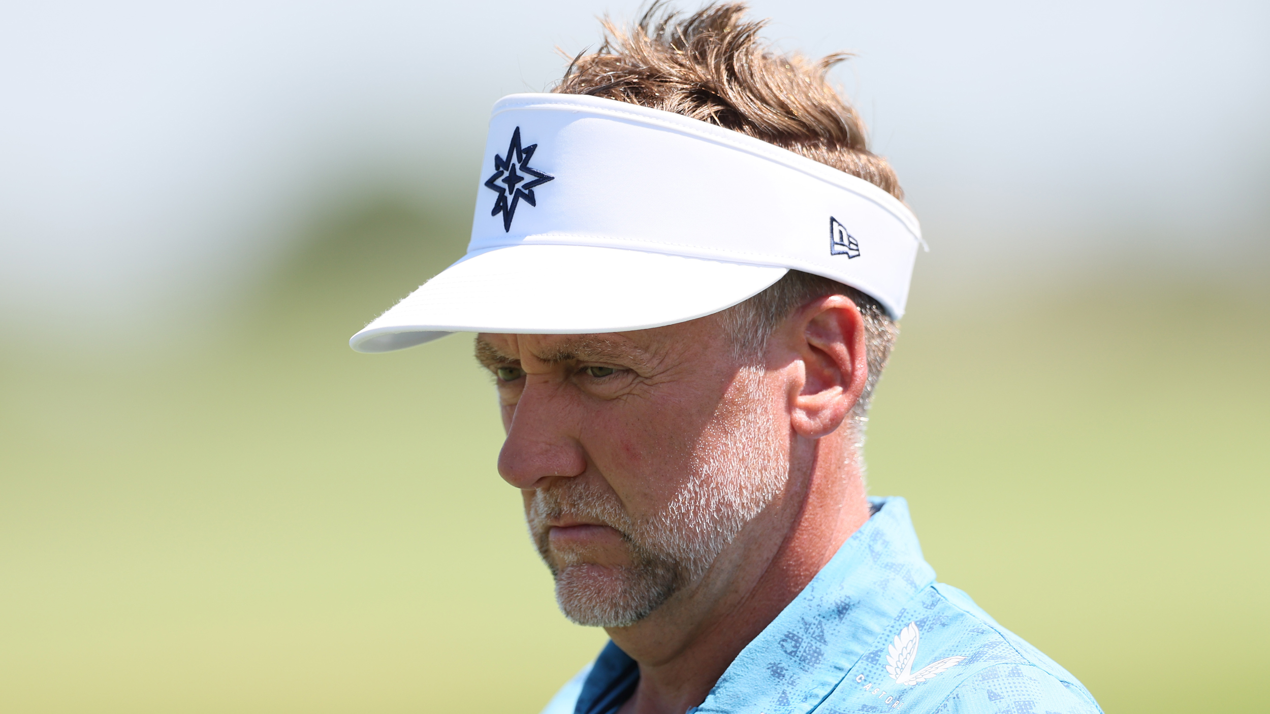 Ian Poulter wearing a sky blue polo and white visor during a LIV Golf tournament