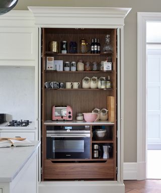 Kitchen with white cabinets and pantry with wood interior