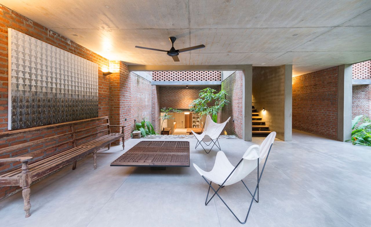 Courtyard with wooden bench, table and two white modern chairs