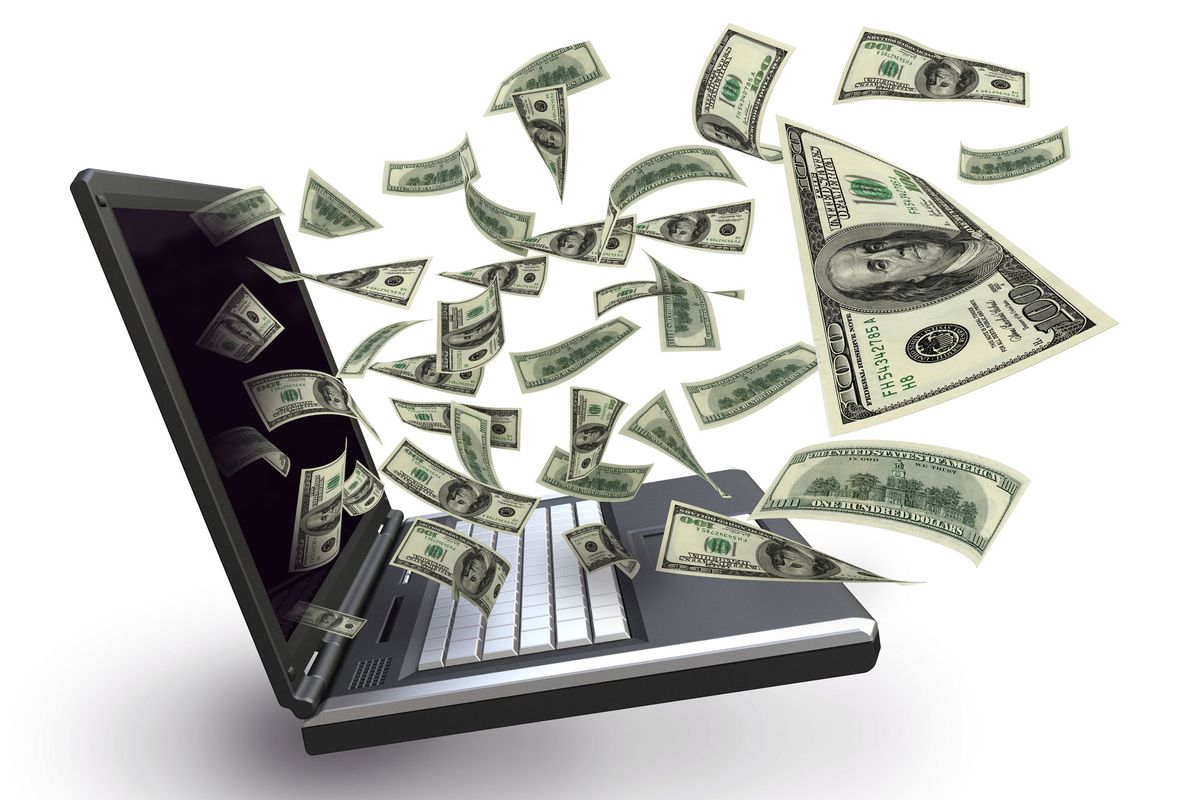 Dollar bills flying out of a laptop screen