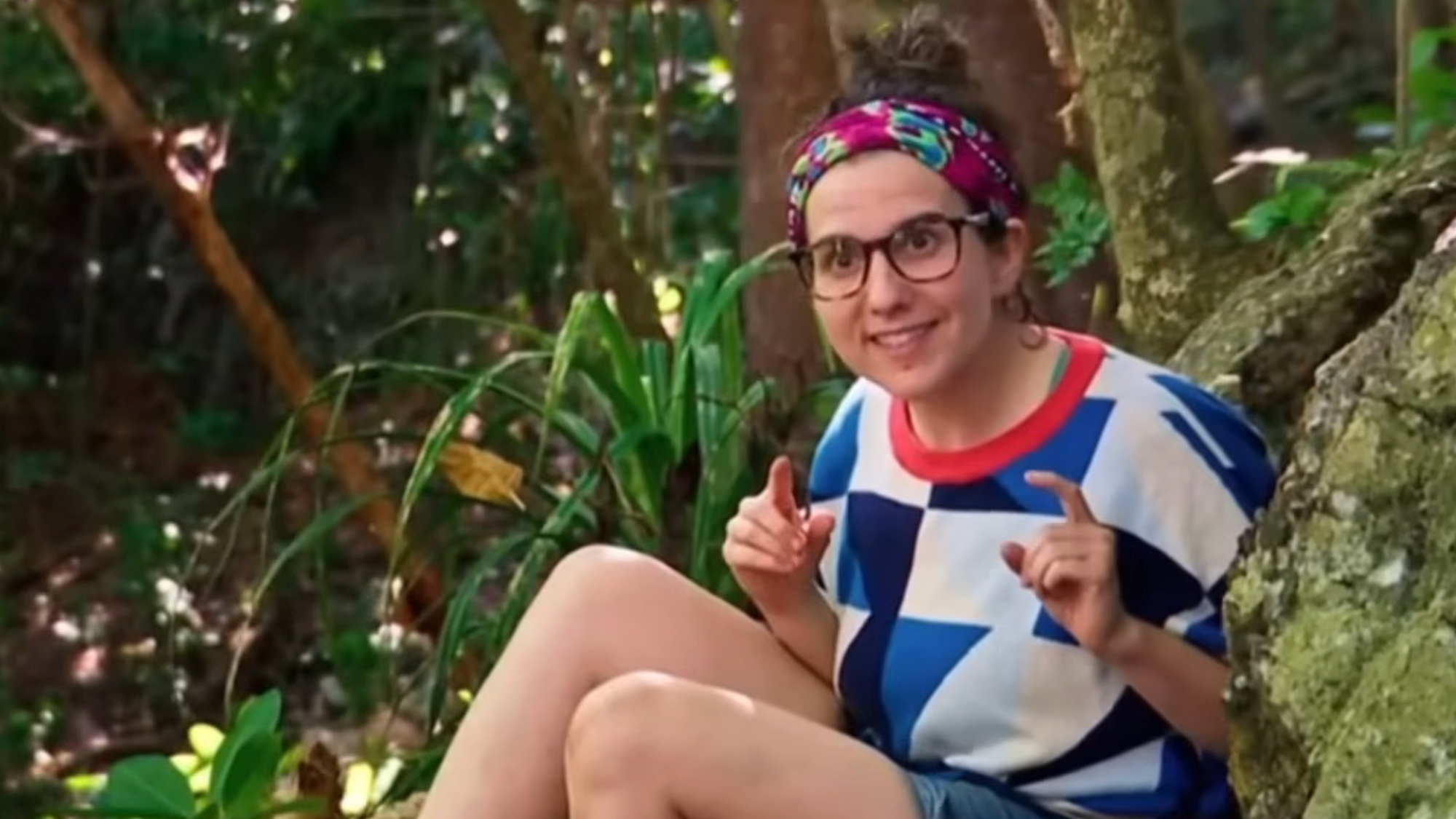 Aubry Bracco talks while sitting in front of a tree on Survivor.