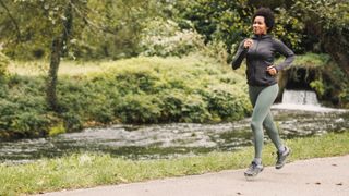 Woman running along path wearing running clothes