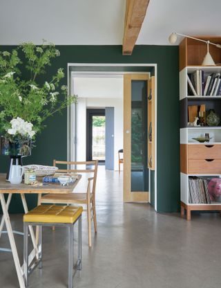 Dark green dining room painted in Farrow & Ball's Studio Green