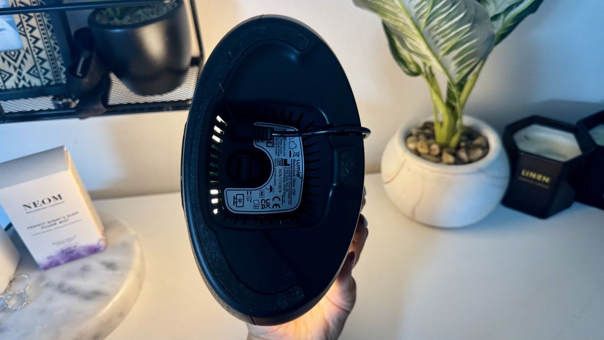 Lumie Bodyclock Glow 150 sunrise alarm clock on bedside table with NEOM pillow spray and plant