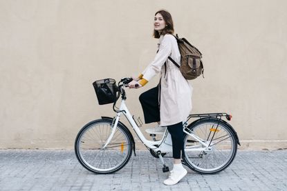 Woman with e-bike at a wall