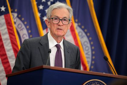 Federal Reserve Chairman Jerome Powell talks to reporters at a podium with American flags and Board of Governors flags behind him