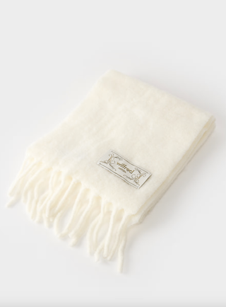 a cream scarf from aritzia in front of a plain backdrop