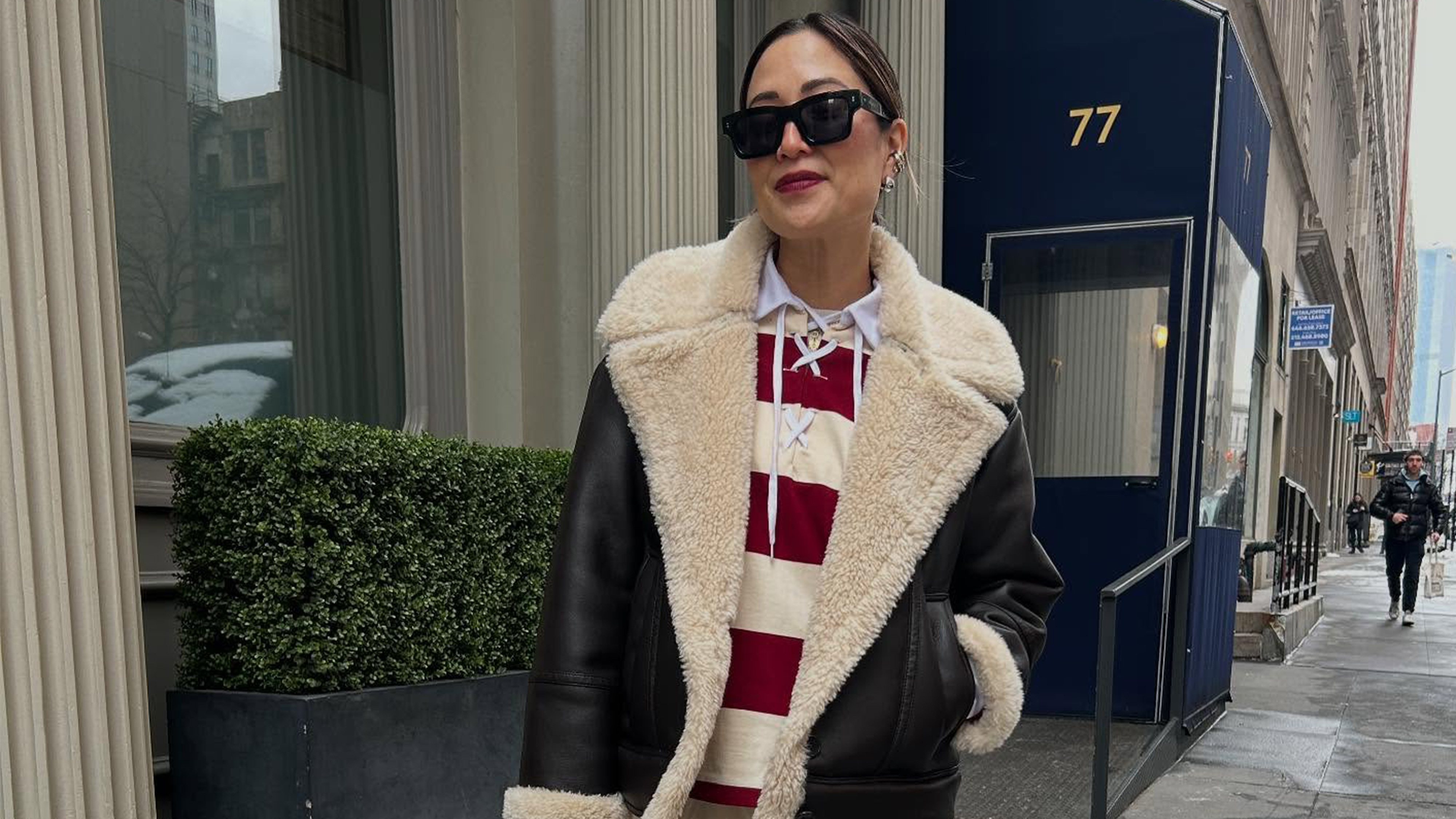 Caroline Maguire wearing a wearing a shearling-lined leather jacket over a striped top.