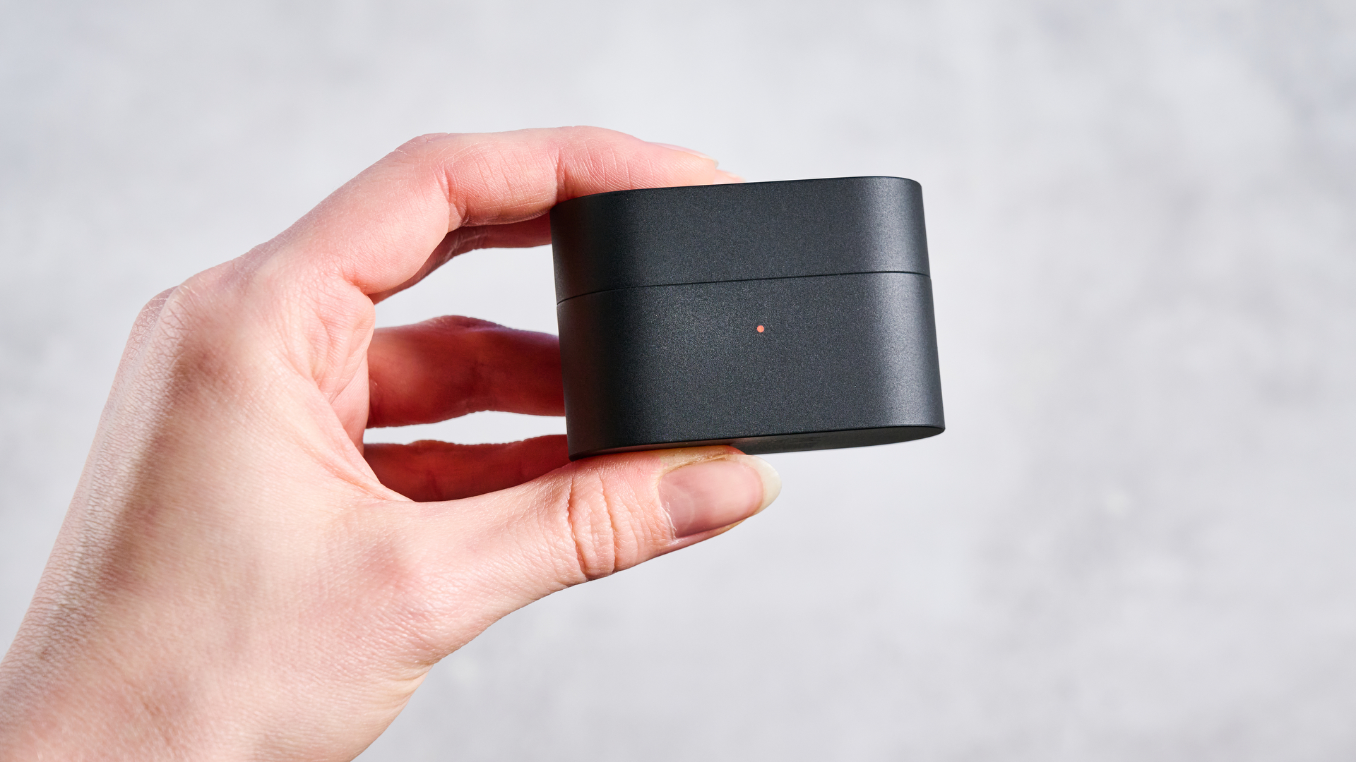 A hand holds the case of the Sony WF-1000XM6 earbud.