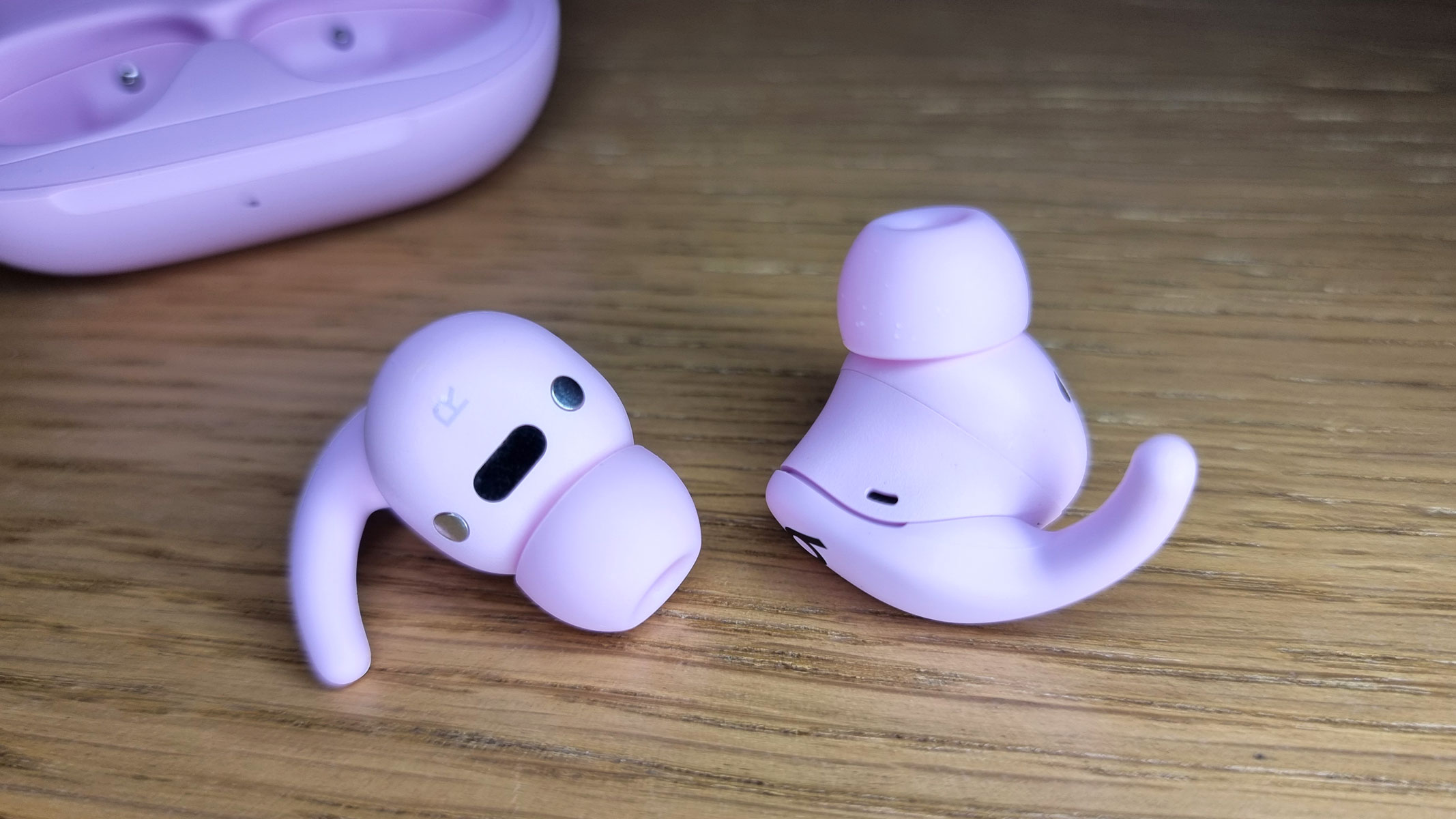 A close-up picture of the Beats Powerbeats Fit earbuds on a table