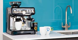 Barista coffee machine on a white kitchen countertop with a turquoise splash back to show how cleaning the coffee machine is a good daily habit to keep your house clean