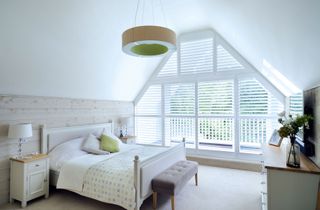 vaulted ceiling with window tratements in bedroom with white scheme and planty of natural light photographed by nigel rigden