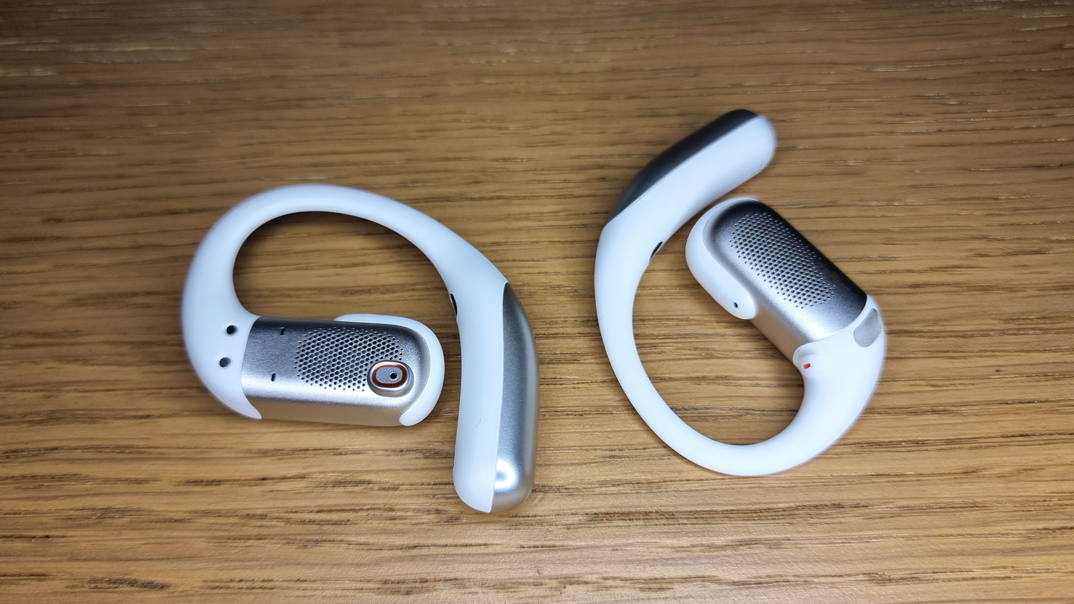 A close-up picture of the Shokz OpenFit Pro earbuds laid out on a table