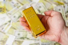 Man holds gold bar on a money banknotes background