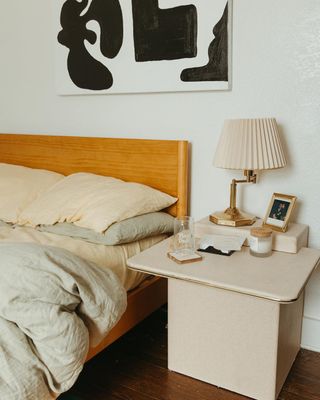 Bed with neutral linen sheets and bedside table
