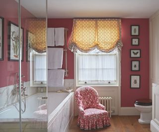 bathroom with red walls and upholstered skirted chair