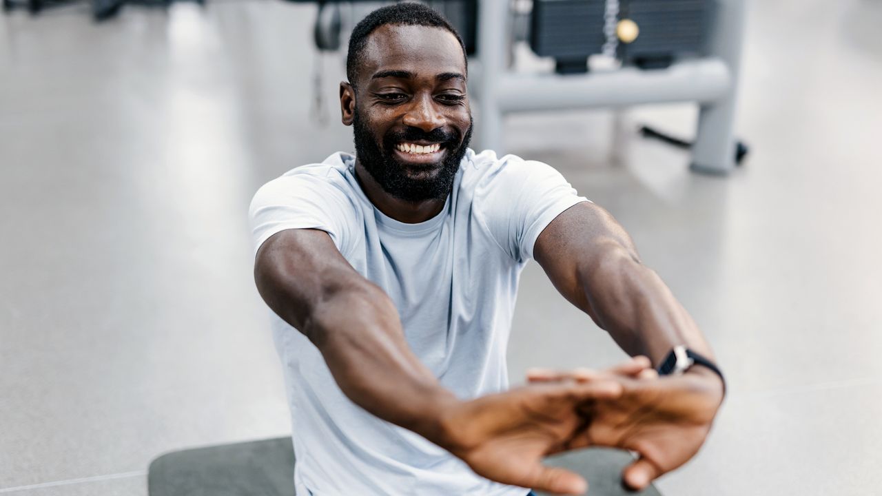 Man in gym stretching his hands