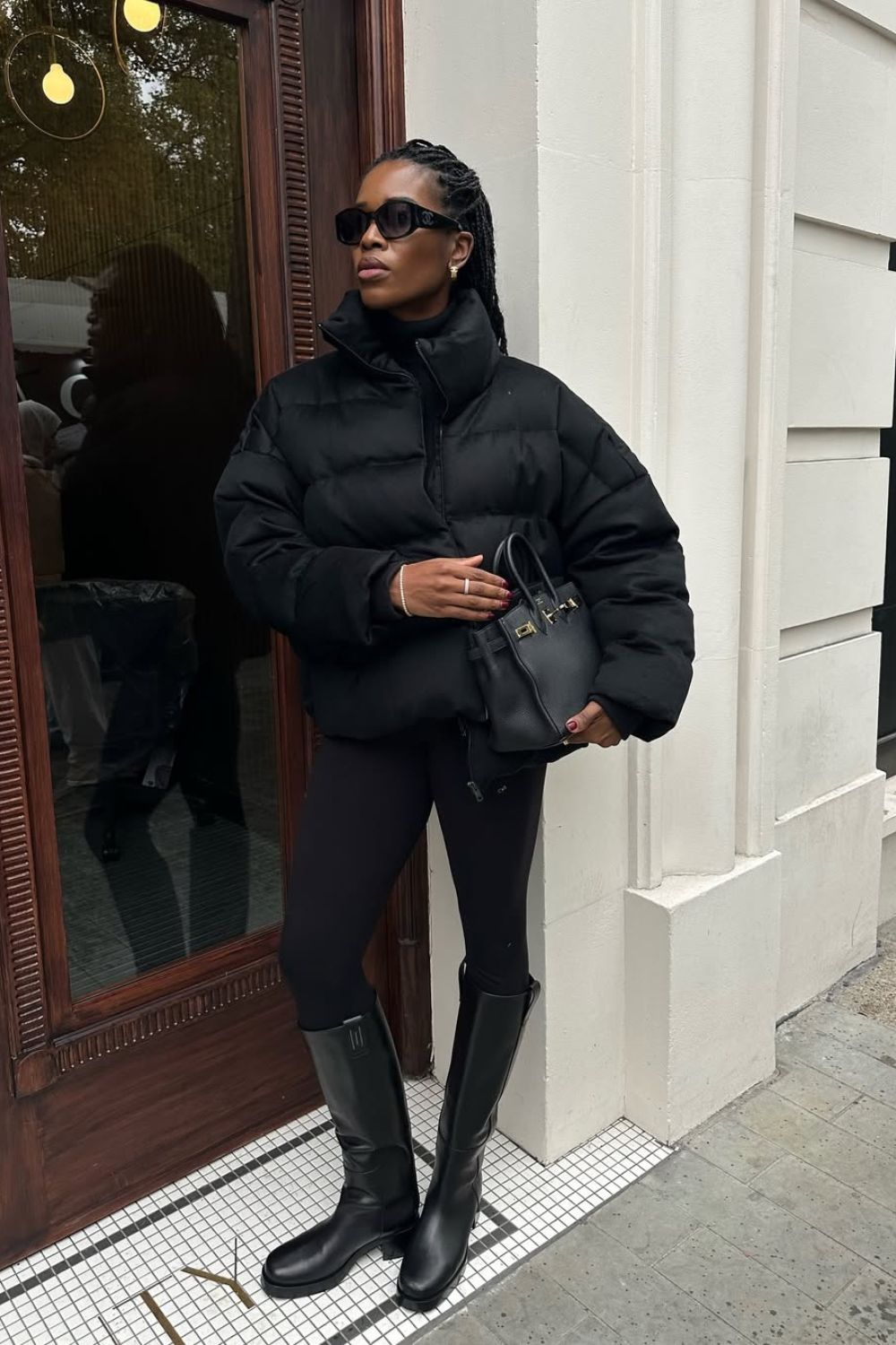 @nlmarilyn wearing black puffer jacket, black leggings and knee-high boots
