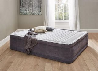 Dreams Comfort Air Bed Kingsize – a huge grey and white airbed in the middle of a room with a wooden floor, with grey walls and a large window with white linen curtains