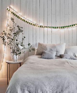 Fairy lights, white bedside table, grey bedsheets