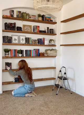 Woman placing books onto a bookshelf