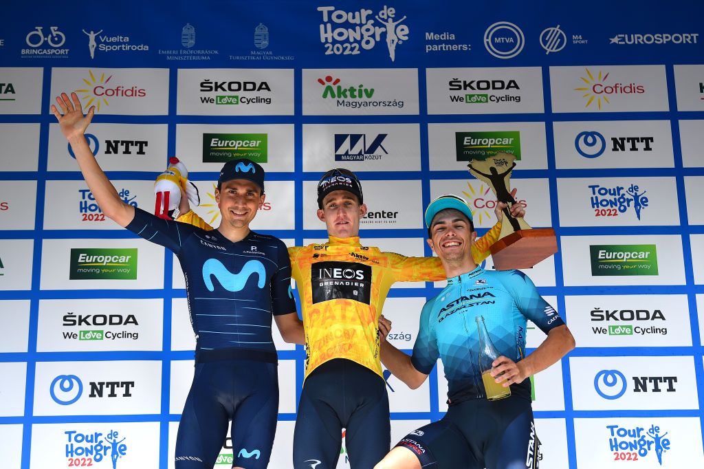 GYNGYSKKESTET HUNGARY MAY 15 LR scar Rodriguez Garaikoetxea of Spain and Movistar Team on second place race winner Eddie Dunbar of Ireland and Team INEOS Grenadiers Yellow Leader Jersey and Samuele Battistella of Italy and Team Astana Qazaqstan on third place pose on the podium ceremony after the during the 43rd Tour de Hongrie 2022 Stage 5 a 184km stage from Miskolc to GyngysKkestet 992m tourdehongrie on May 15 2022 in GyngysKkestet Hungary Photo by Dario BelingheriGetty Images