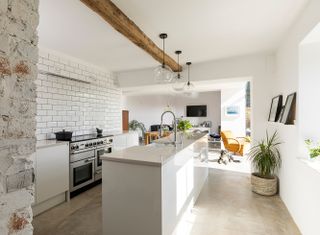contemporary white gloss kitchen in conversion with ceiling beams