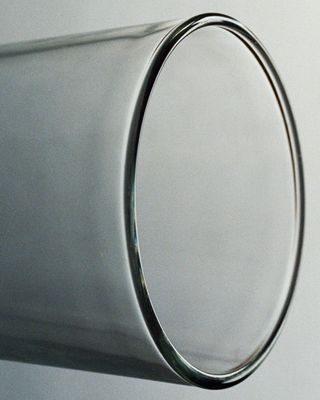 Closeup of the top rim of a drinking glass which is tilted to the side.