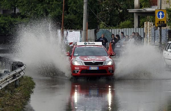 An official's car hits some standing water on the course.