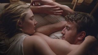 A still from the movie Foe, showing Saoirse Ronan as Hen and Paul Mescal as Junior, Hen's husband embracing naked on a bed.