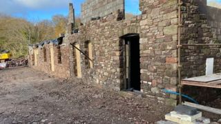 A dilapidated stone wall of a farmhouse