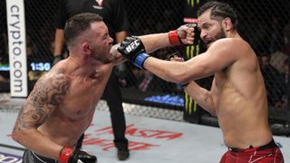 Colby Covington punches Jorge Masvidal in their welterweight fight during the UFC 272