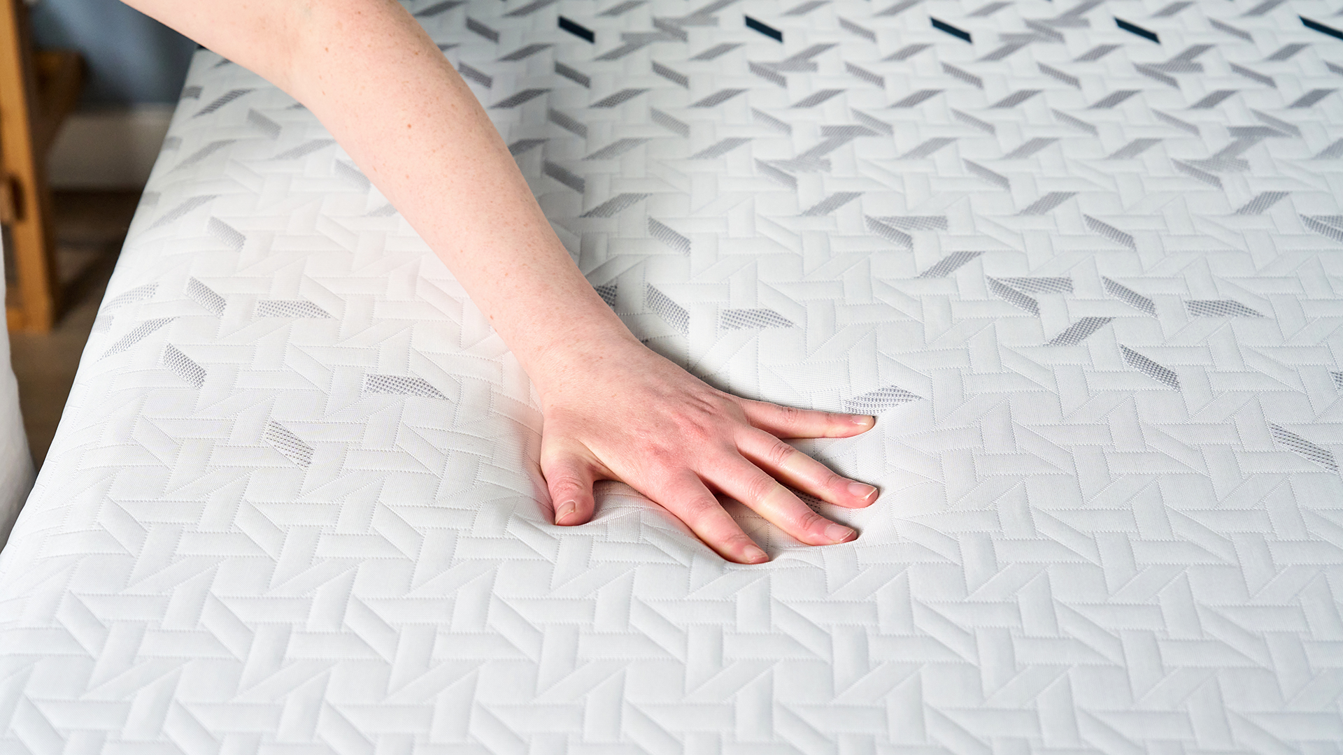 A hand resting on the surface of the cooling cover of the Nectar Ultra Hybrid mattress