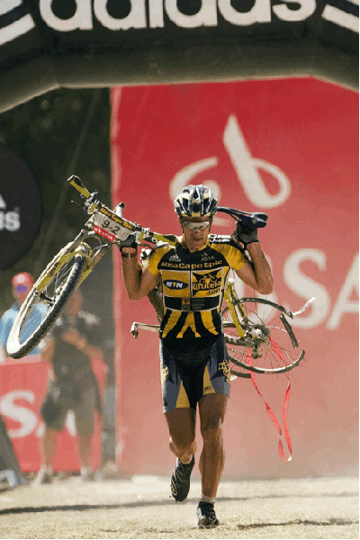 Alban Lakata on his way to the finish line with his bike on his shoulders in the 2010 Absa Cape Epic.