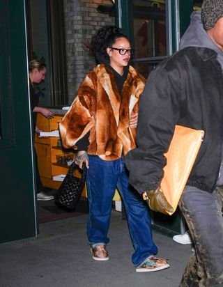 Rihanna wearing a fur coat with baggy jeans and colorful shoes plus a bottega bag