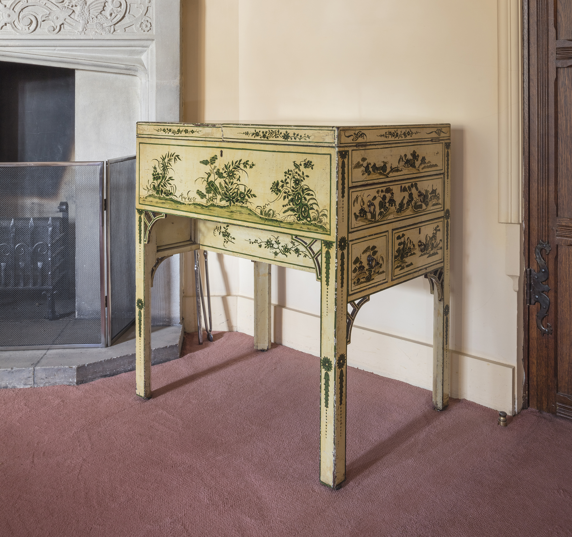 The Garrick Dressing Table (1775) made by Thomas Chippendale in situ at Anglesey Abbey, Cambridgeshire A white and green japanned mahogany dressing table, by Thomas Chippendale (1718 - 1779) London, circa 1775. Ordered and made for the best dressing room at Garrick&#039;s Villa, Hampton, owned by David and Eva Garrick and part of a suite of bedroom furniture supplied by Thomas Chippendale. The dressing table with a double hinged top opening at the centre and enclosing a fitted interior of lidded wells and open compartments for bottles and containers centred by a mahogany framed retractable and adjustable mirror, rising on a ratchet mechanism. With false and true drawers to the sides and raised on square section chamfered legs headed by pierced spandrels or corner brackets, brass casters. The top japanned and decorated with figures and pagodas within landscape scenes incorporating trees and shrubs and framed with a Greek key border. The front and sides decorated with conforming scenes and with foliage and exotic birds. The legs with flower head medallions and bell flower drapes. Glass top for protection.