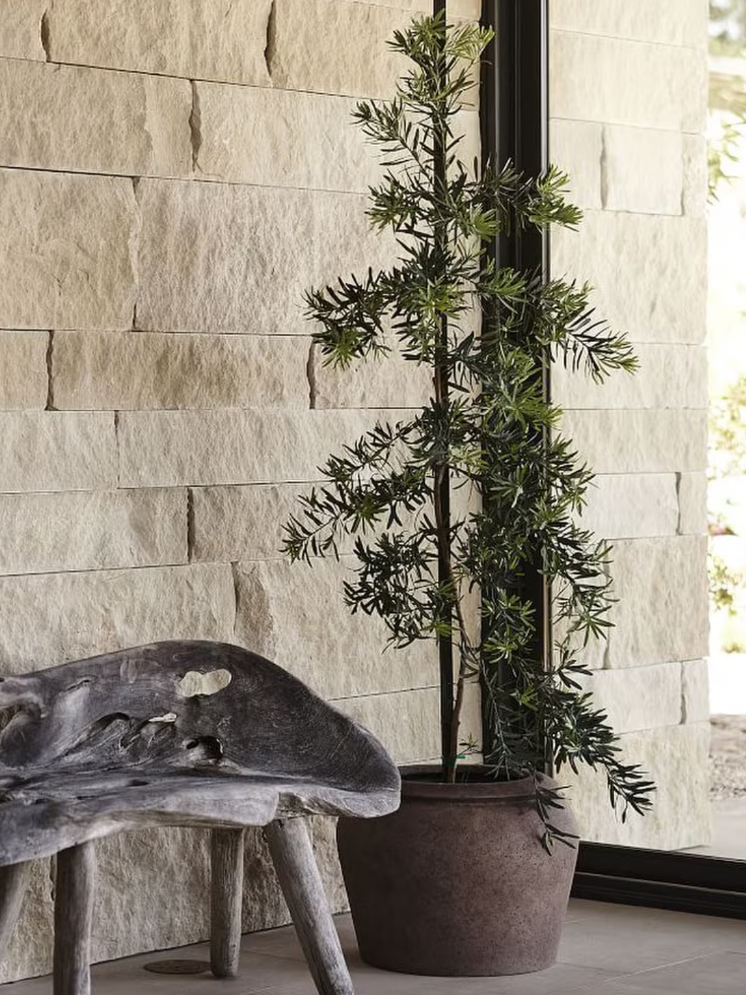 A patinaed outdoor planter beside a wood bench