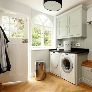 room with washing machine and wooden flooring