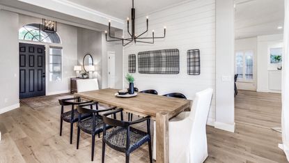 farmhouse kitchen dining table with black chairs and black chandelier