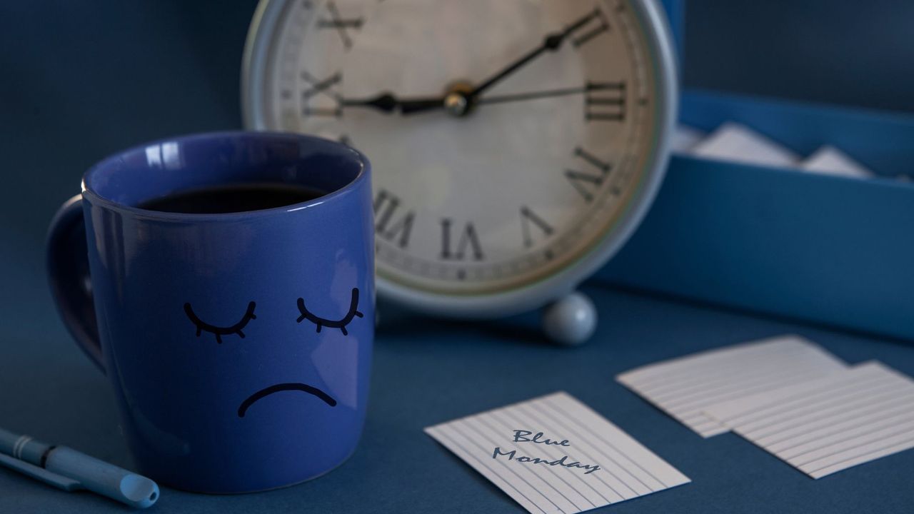 Blue cup with a sad face, and card reading &#039;Blue Monday&#039;