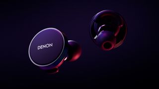 Denon PerL Pro earbuds in low lighting, on dark background 